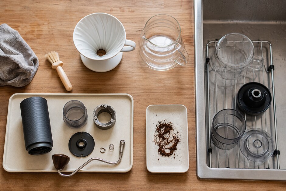 Dry grinder parts and washable brewer components arranged separately with brushes and cleaning cloths.